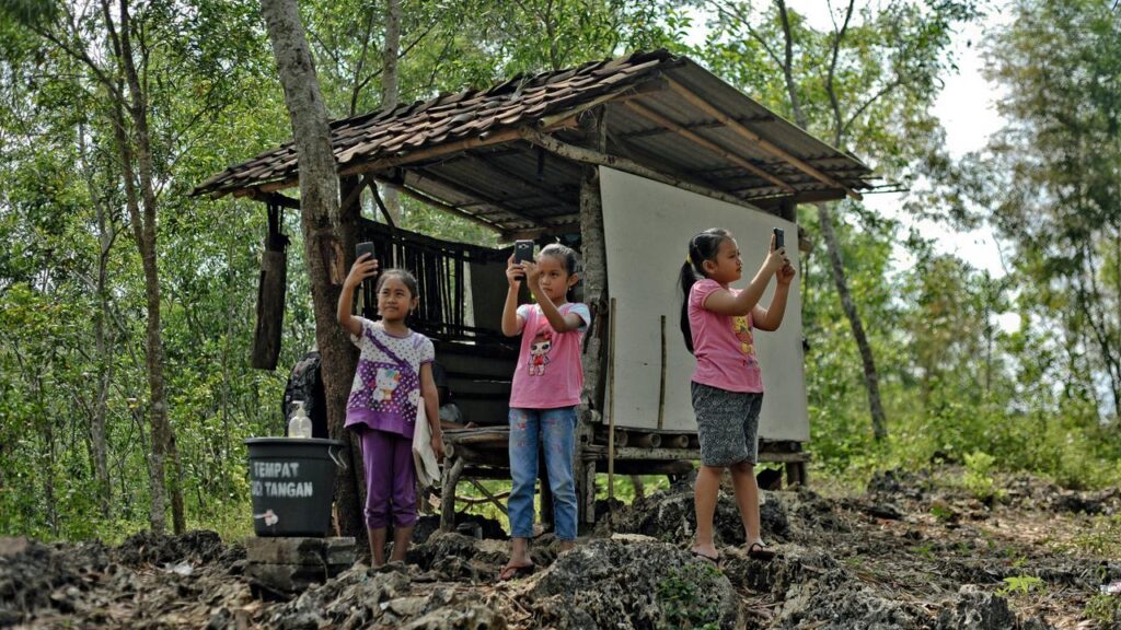 School age students searching for internet signal around Gunung Kidul, Yogyakarta (source photo by Agus Supriyanto / AFP)