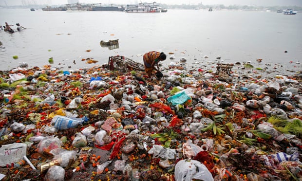 A woman collects items thrown into the Ganges as religious offerings after celebrations marking the last day of the Navratri festival in Kolkata, India. Photograph: Rupak de Chowdhuri/Reuters