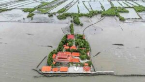 The Buddhist temple surrounded by seawater with the Bangkok skyline visible in the distance. Photograph: Manan Vatsyayana/AFP/Getty Images