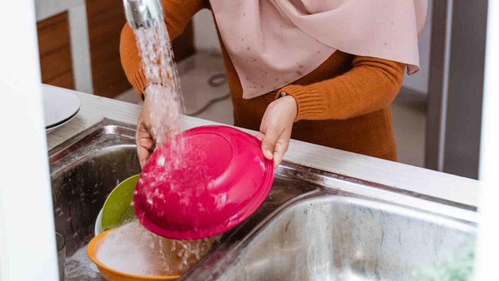 Muslim Woman Washing the Dishes by Odua Images