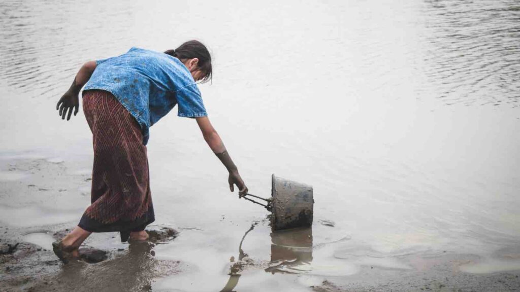 Woman hand are scooping water on cracked ground, Crisis of water shortage by R_Tee from Getty Images Pro