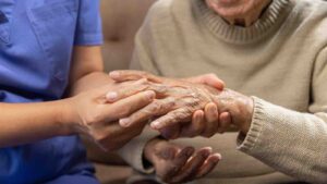 Caregiver massaging wrist of elderly woman in painful swollen go by toa55 from akaratwimages