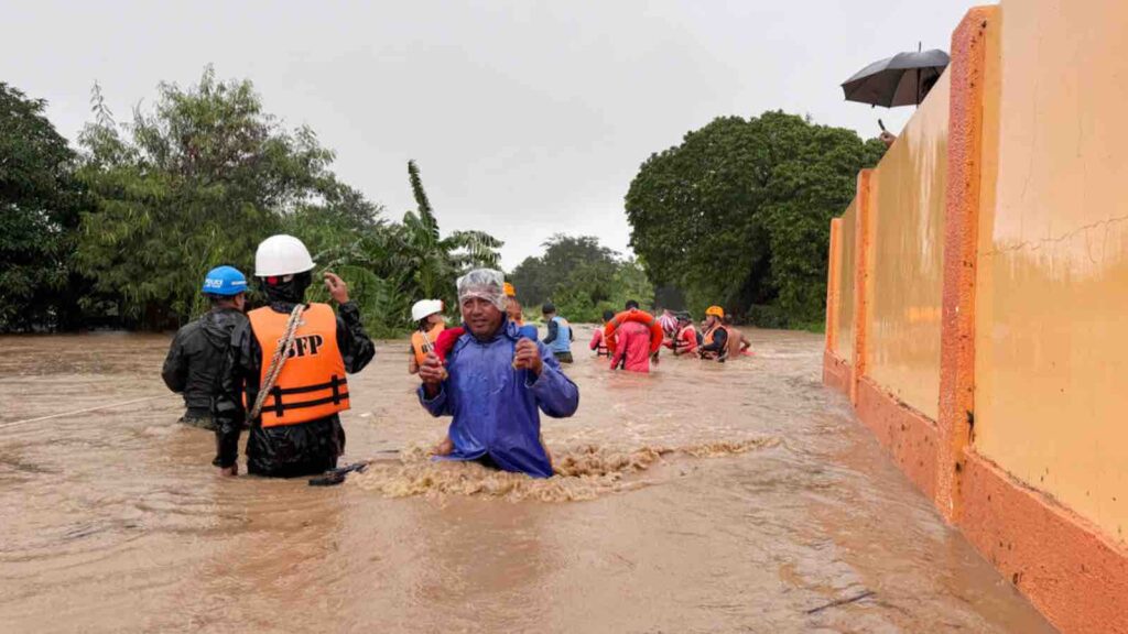 Residents negotiate floods caused by powerful Typhoon Krathon locally called "Typhoon Julian" at Bacarra, Ilocos Norte province, northern Philippines on Monday, Sept. 30, 2024. (AP Photo/Bernie Dela Cruz)