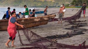 Fisherfolk in Pagudpud, Philippines untangle and prepare their nets for the late evening fishing offshore to catch small tuna. Image: FotoGrazio, Flickr