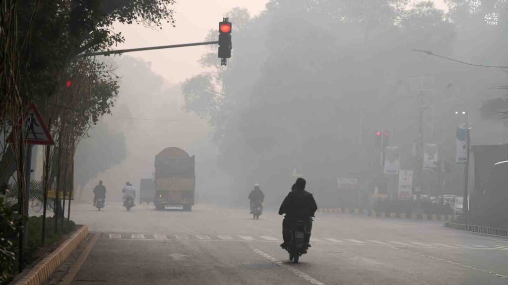 Vehicles and motorcyclists amid severe air pollution in Lahore, Pakistan, November 24, 2023. © 2023 K.M. Chaudary/AP Photo