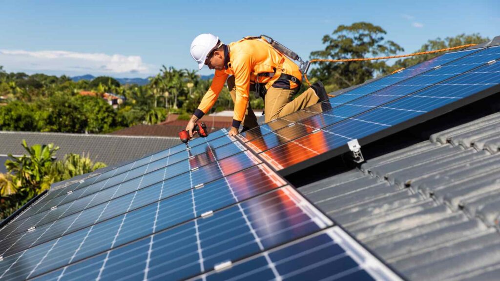 Solar panel technician with drill installing solar panels by zstockphotos